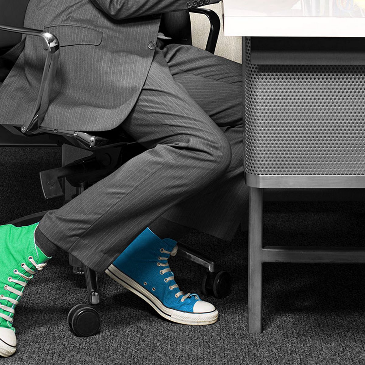 Une personne assise avec deux chaussures de couleur